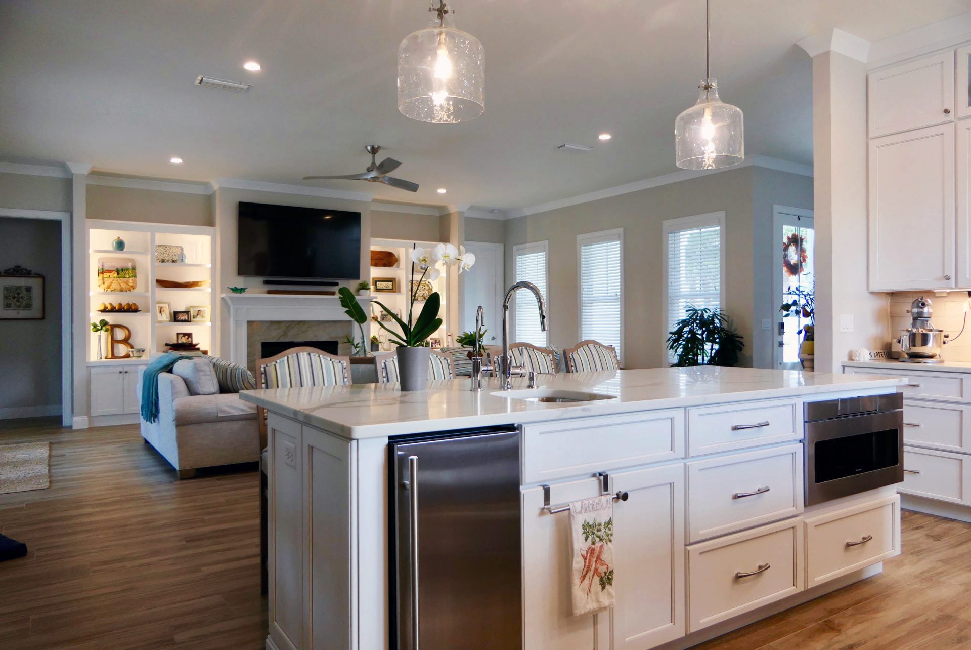 Modern kitchen with a large island and elegant lighting.