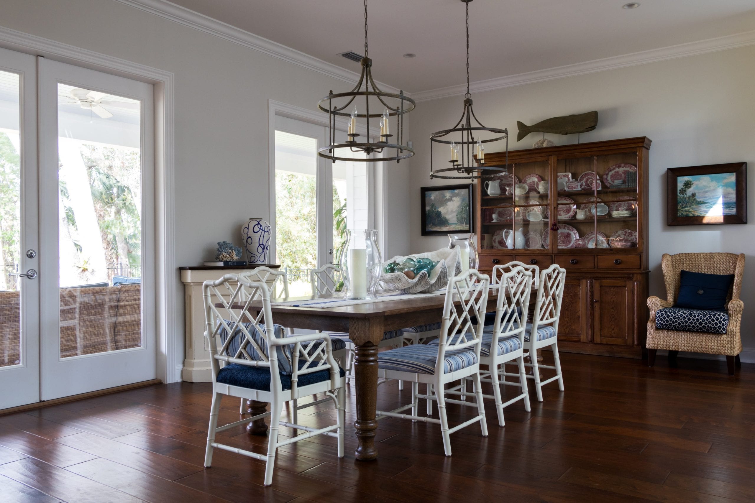 Elegant dining room with white chairs and wooden floor.