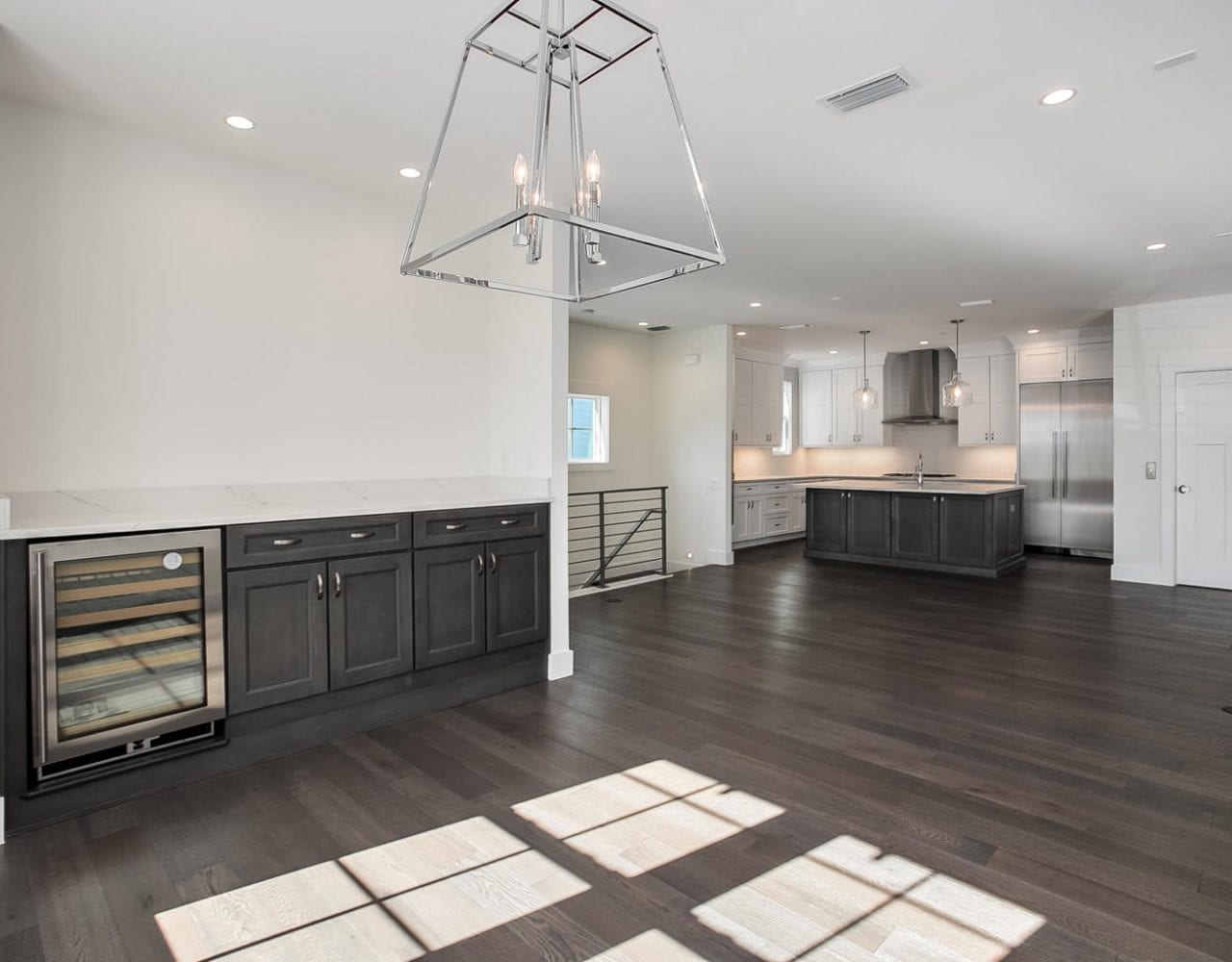 Spacious modern kitchen with dark wood floors and island.