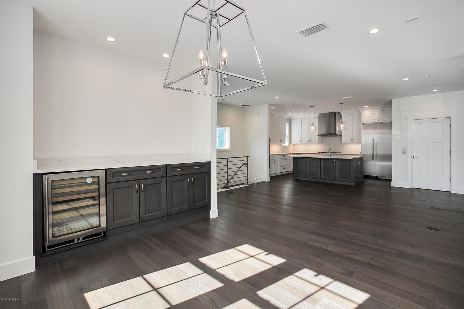 Spacious modern kitchen with dark wood floors and island.