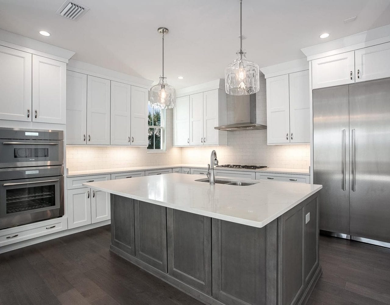 Modern kitchen with white cabinets and a large gray island.