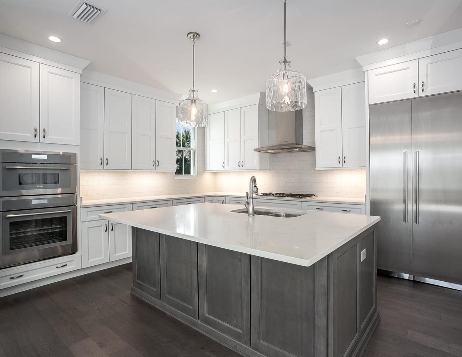 Modern kitchen with white cabinets and a large gray island.