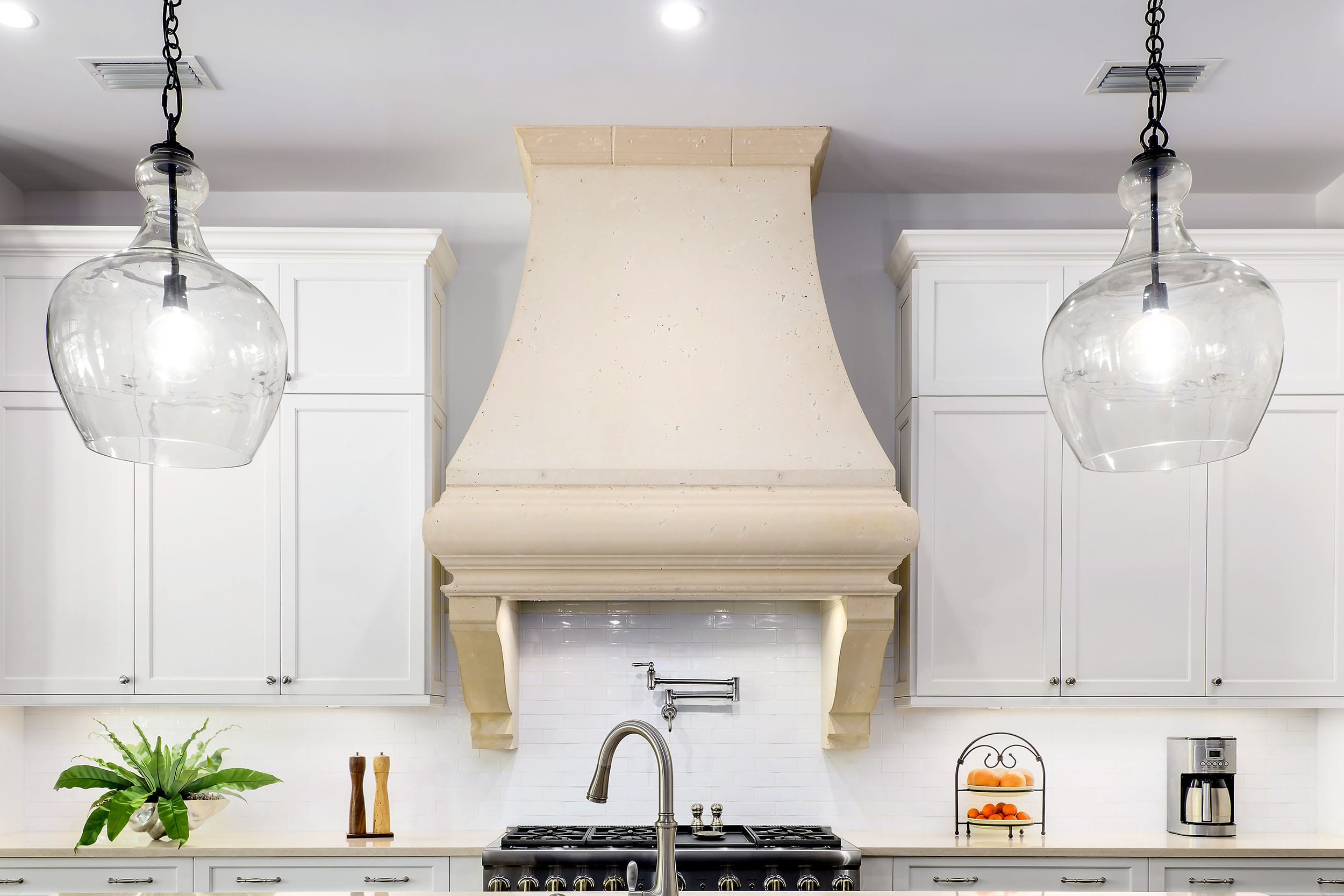 Elegant kitchen with a large beige range hood and white cabinetry.