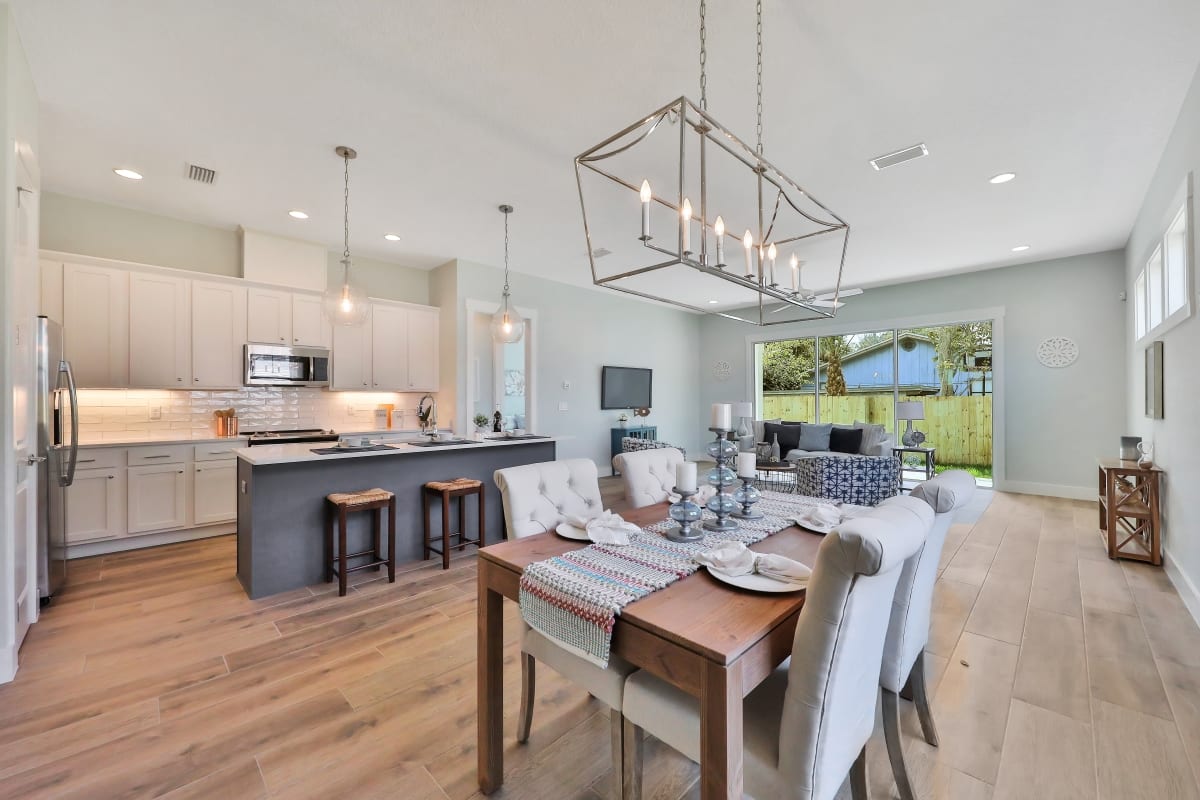 Bright open-concept kitchen and dining area with modern decor and large windows.