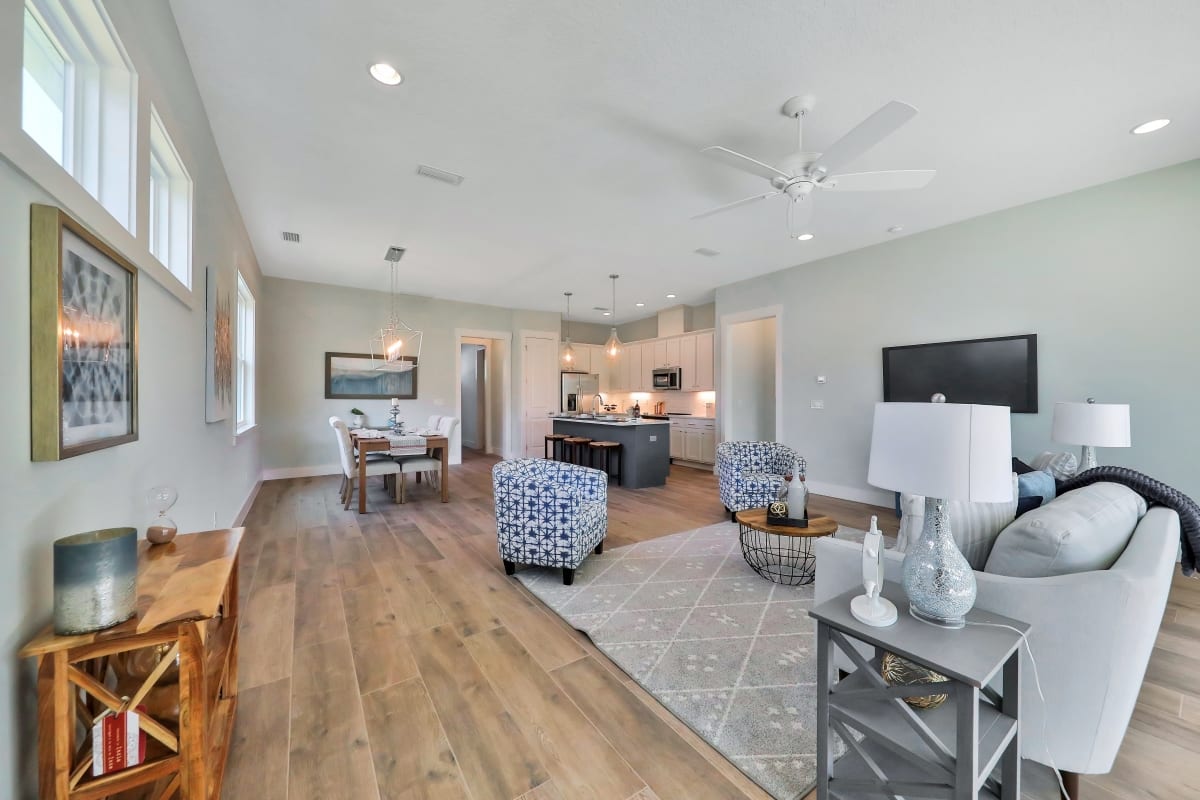 Spacious living room with modern décor, wooden floors, and open kitchen.