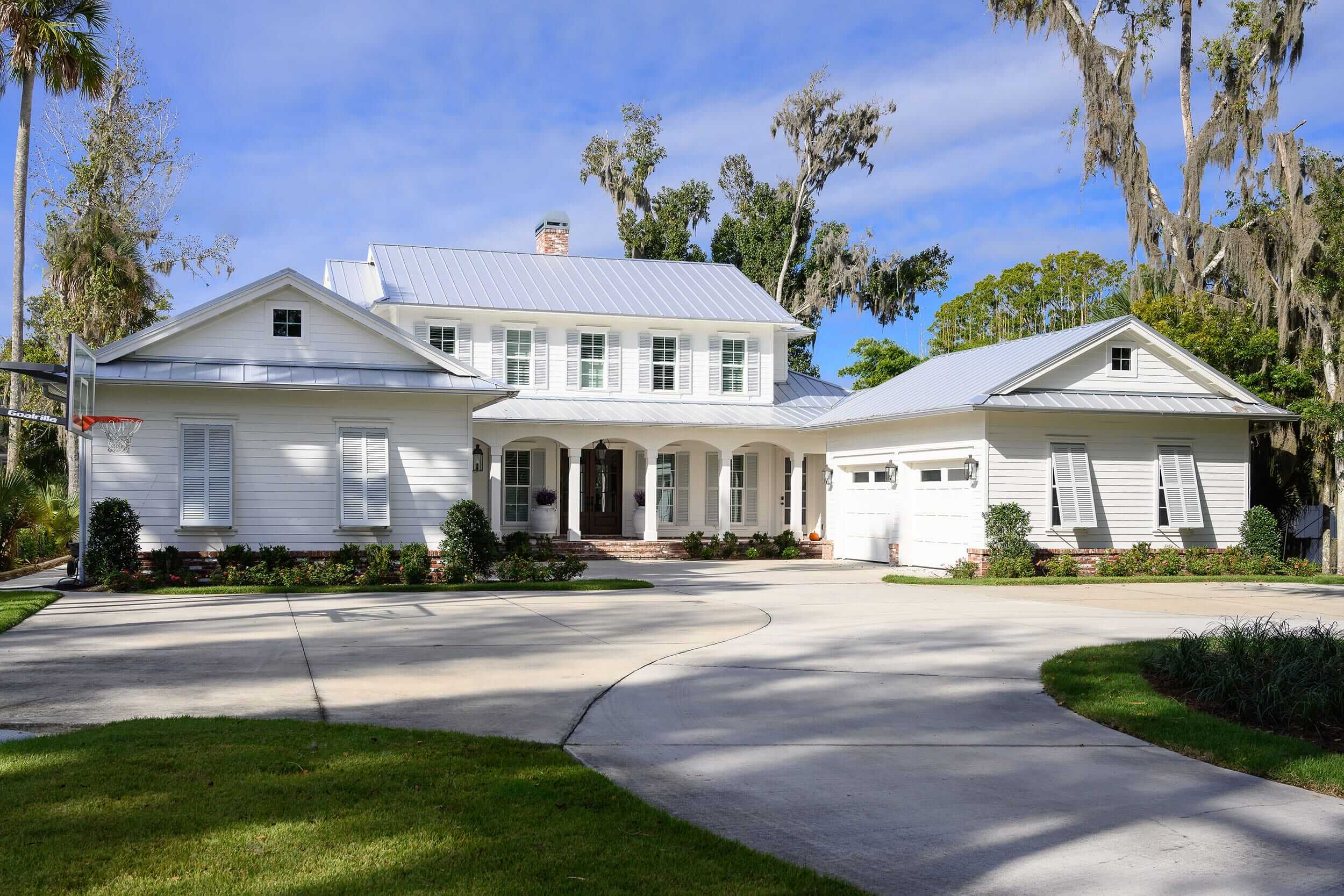 Spacious two-story white house with a large driveway and attached garage.