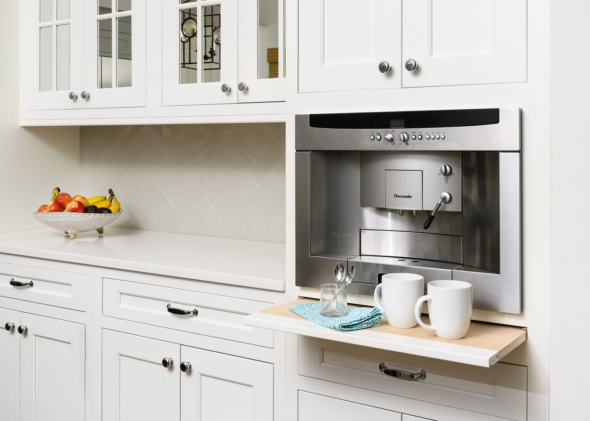 Built-in coffee machine integrated into white kitchen cabinetry.