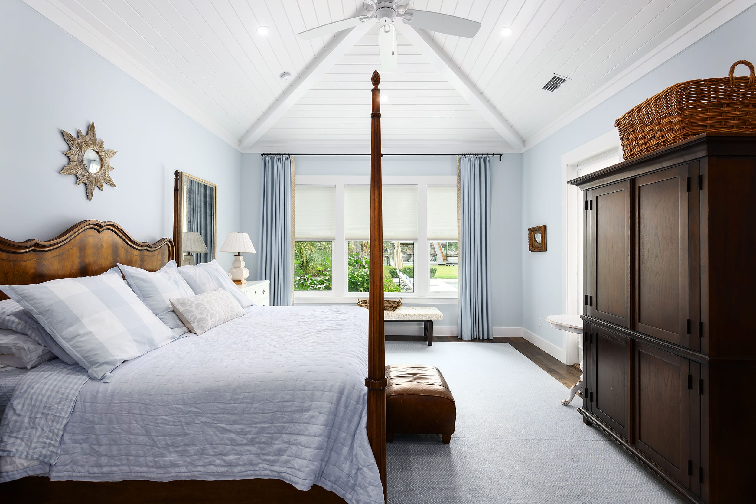 Bright and airy bedroom with a four-poster bed and large window.