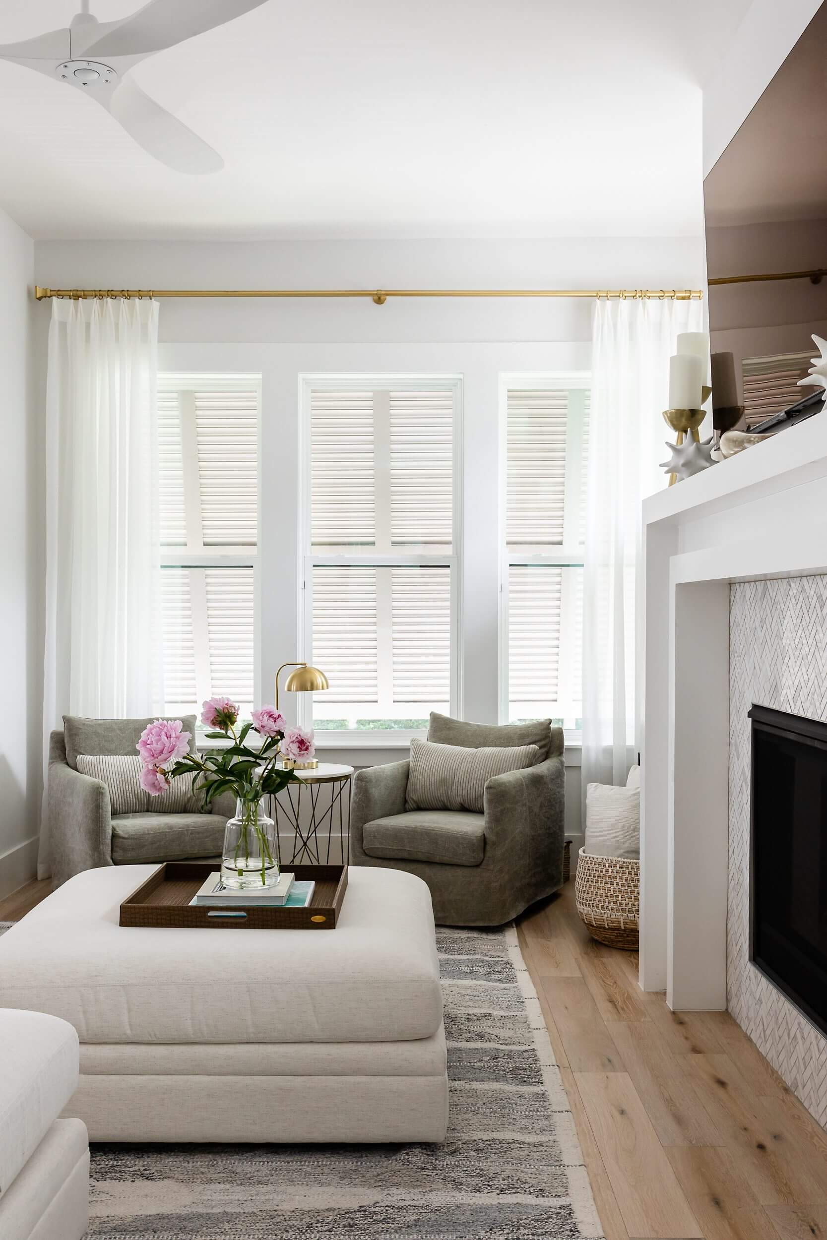 Bright living room with neutral tones and soft pink flowers on a tray.