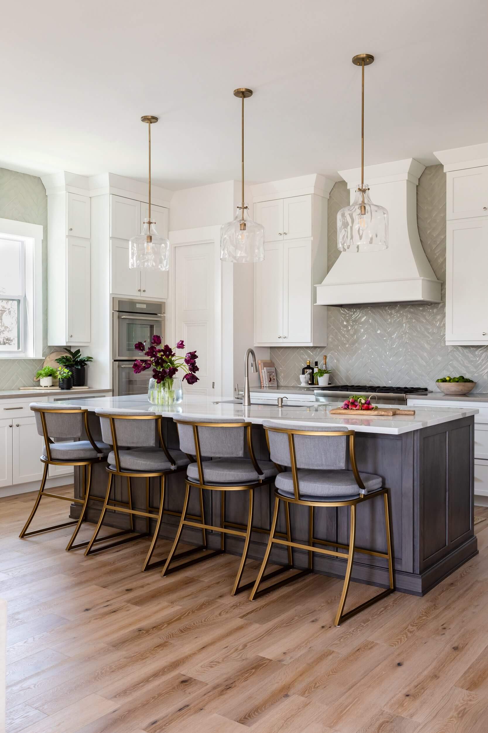 Modern kitchen with white cabinets, a large island, and stylish bar stools.